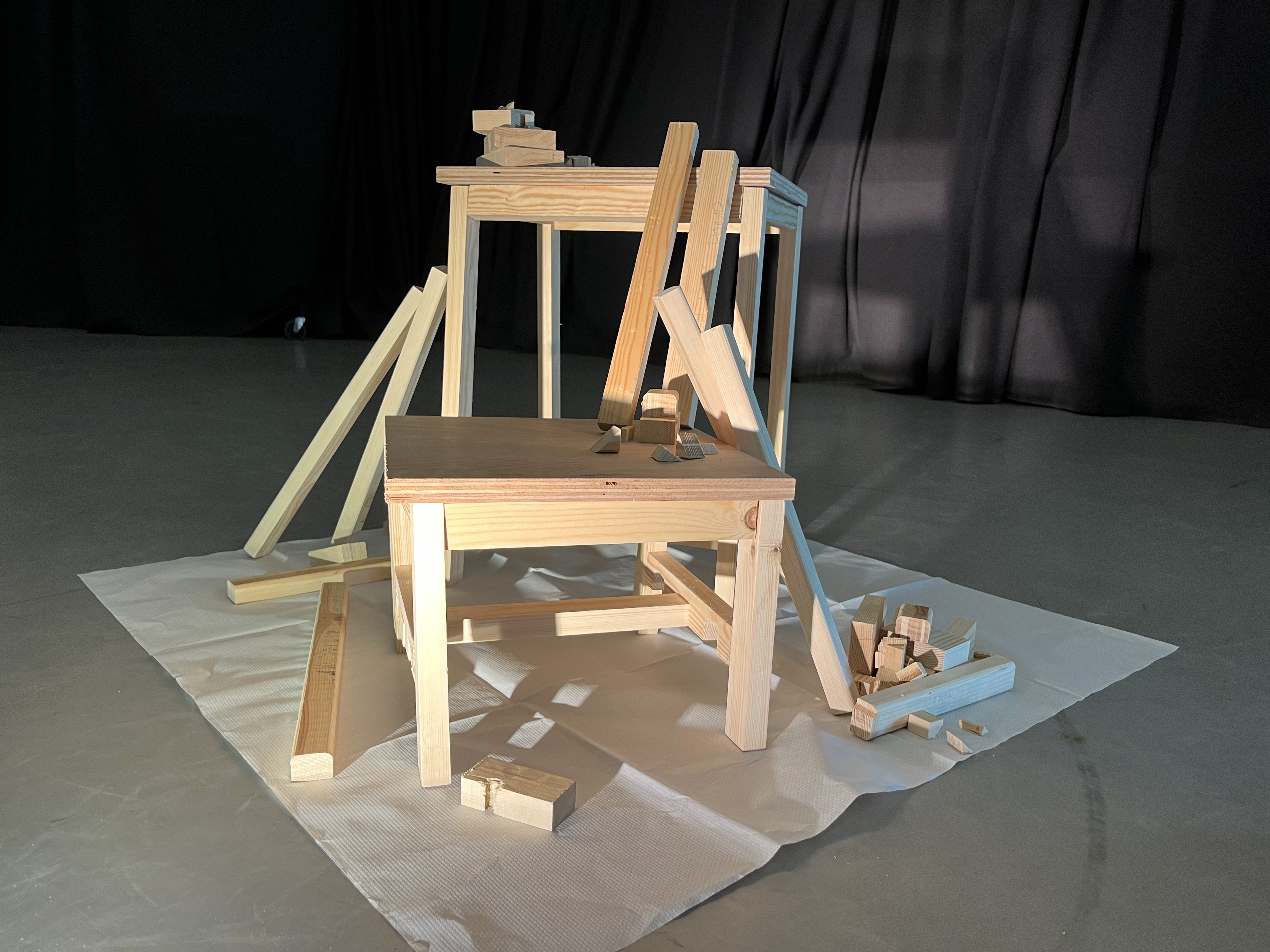 A wooden step stool covered in smaller bits of scrap wood, lit elegantly